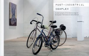A photograph of the cover of the ‘Post-Industrial Complex’ sourcebook. It shows a photograph of the ‘Post-Industrial Complex’ exhibition at the Museum of Contemporary Art Detroit. In the foreground are two modified bicycles. Text on the cover reads, “Post-Industrial Complex A small sample of the diverse range of brainpower that exists in metro Detroit.”
